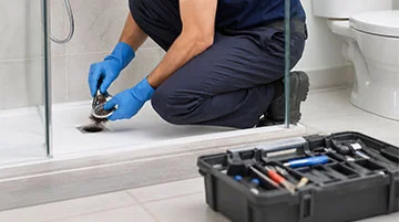 Técnico revisando un desagüe para evitar atascos en fregadero ducha y WC